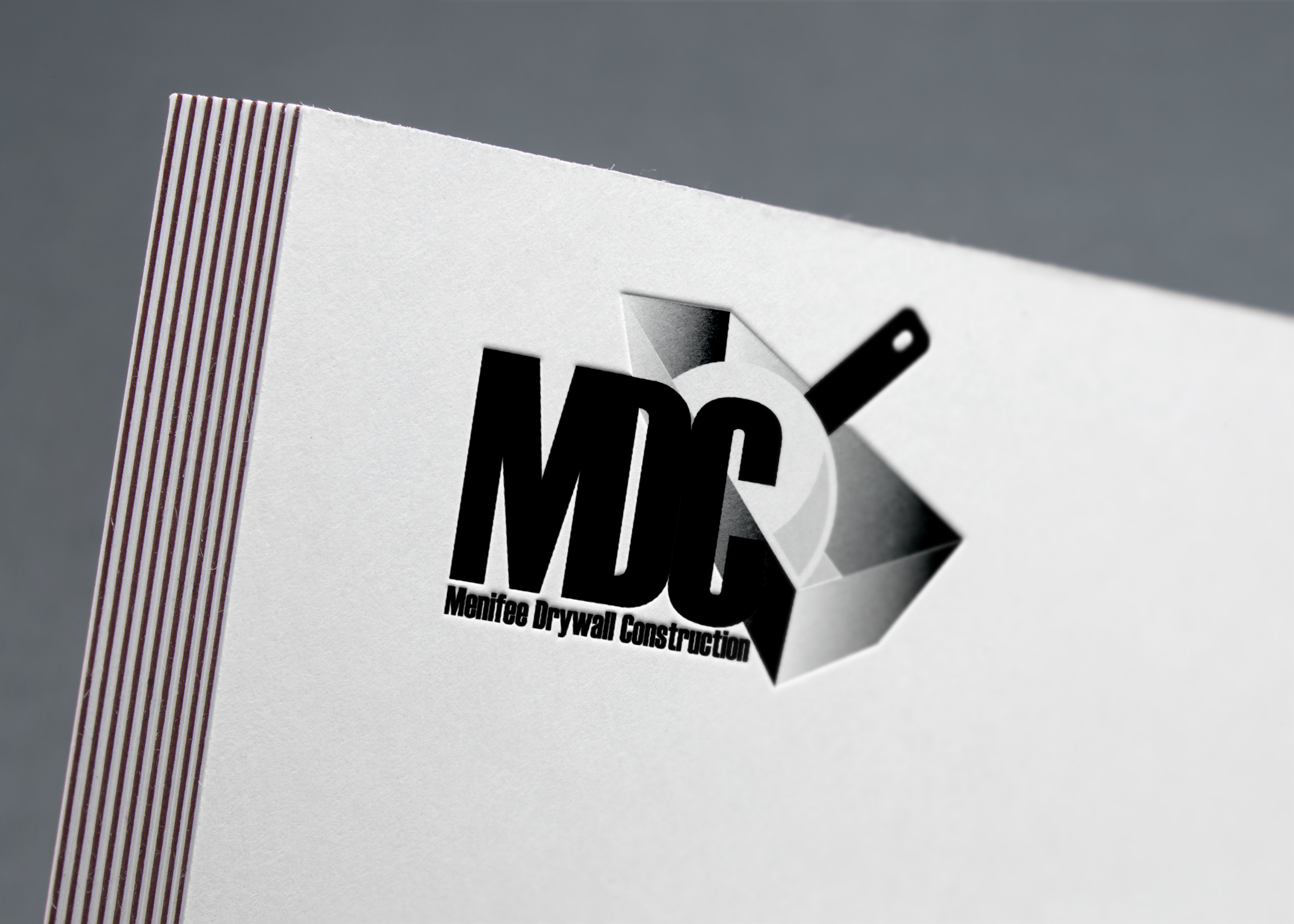 MDC brand logo printed and embossed on a card.